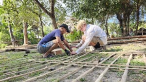 Finn Clair contributing to building a house with members of the community.