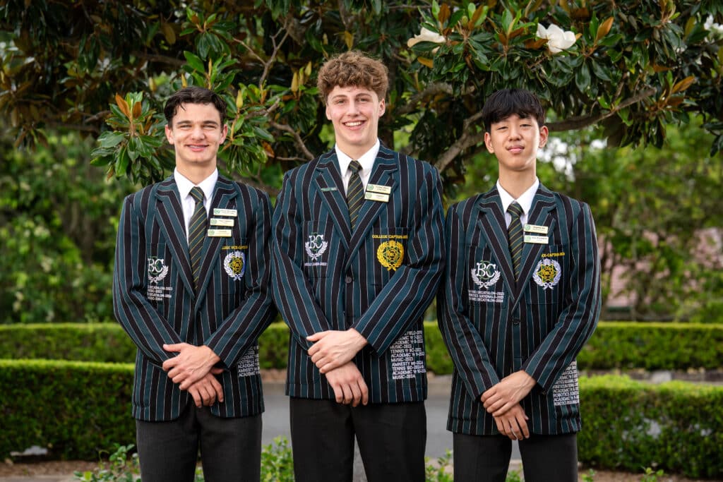 Three students smiling at the camera. They are the 2026 captains for Brisbane Boys' College.